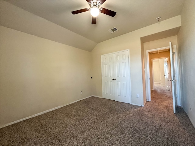 unfurnished bedroom with ceiling fan, a closet, dark carpet, and vaulted ceiling