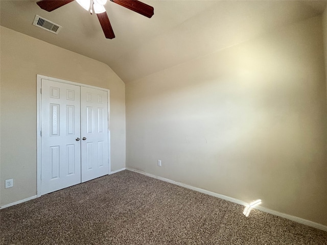 unfurnished bedroom with ceiling fan, a closet, carpet floors, and lofted ceiling