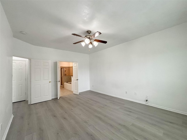 unfurnished bedroom featuring ceiling fan, connected bathroom, and light hardwood / wood-style flooring