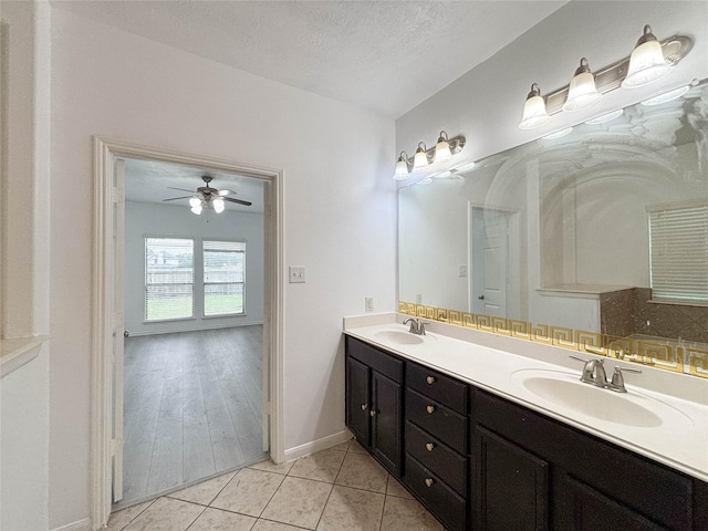 bathroom featuring tile patterned flooring, vanity, a bathtub, and a textured ceiling