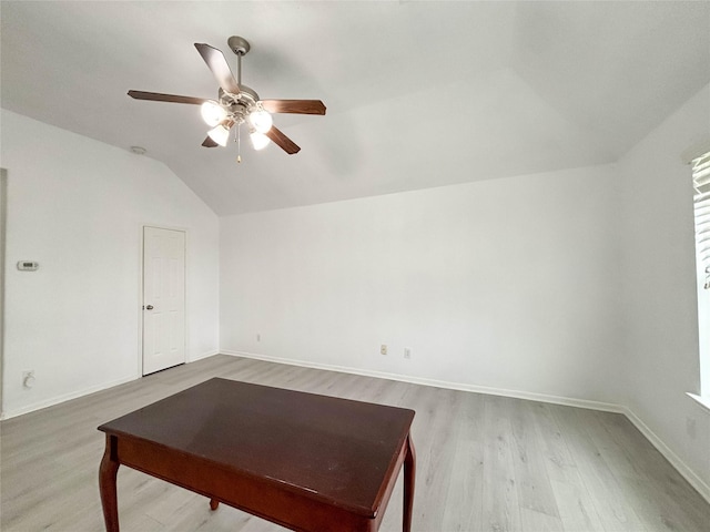 living room with ceiling fan, light hardwood / wood-style floors, and vaulted ceiling