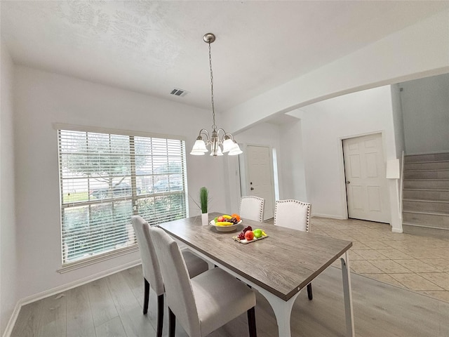 dining space featuring a notable chandelier and light wood-type flooring