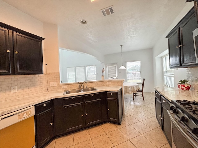 kitchen with dishwasher, sink, backsplash, hanging light fixtures, and light tile patterned floors