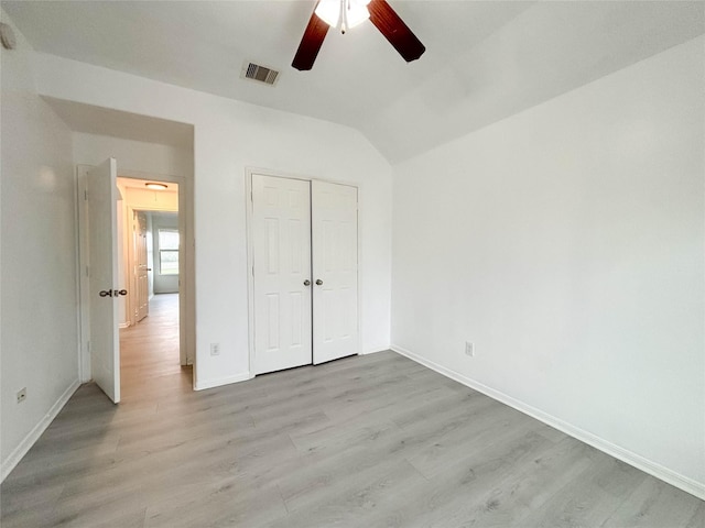 unfurnished bedroom featuring light hardwood / wood-style flooring, a closet, ceiling fan, and vaulted ceiling