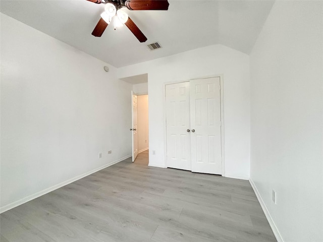 unfurnished bedroom featuring ceiling fan, lofted ceiling, light hardwood / wood-style floors, and a closet