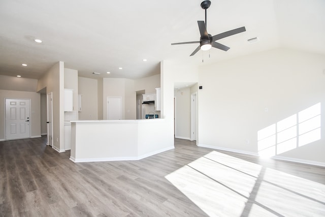 unfurnished living room featuring ceiling fan, lofted ceiling, and hardwood / wood-style flooring