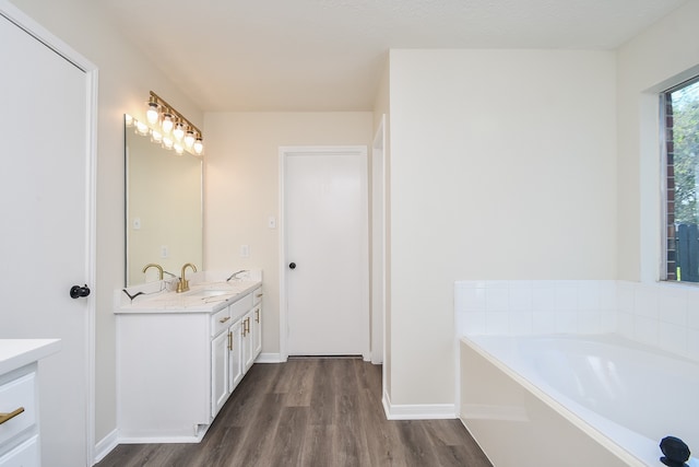 bathroom with a tub, vanity, and hardwood / wood-style flooring