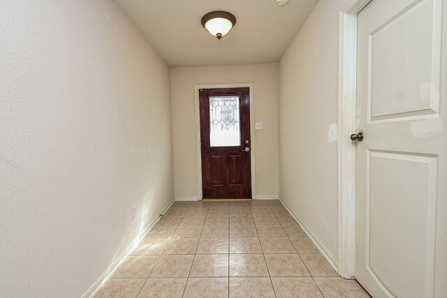 doorway to outside with light tile patterned flooring