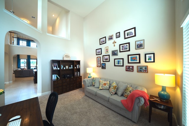 living room featuring carpet flooring and a towering ceiling