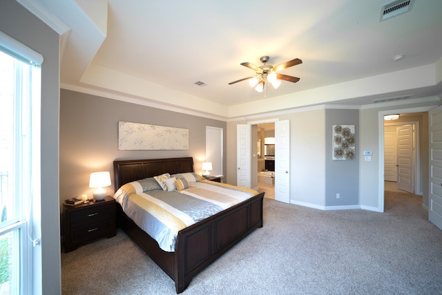 carpeted bedroom featuring ceiling fan, ensuite bath, crown molding, and multiple windows