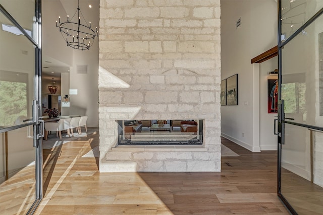 living room with hardwood / wood-style floors, a fireplace, and a high ceiling