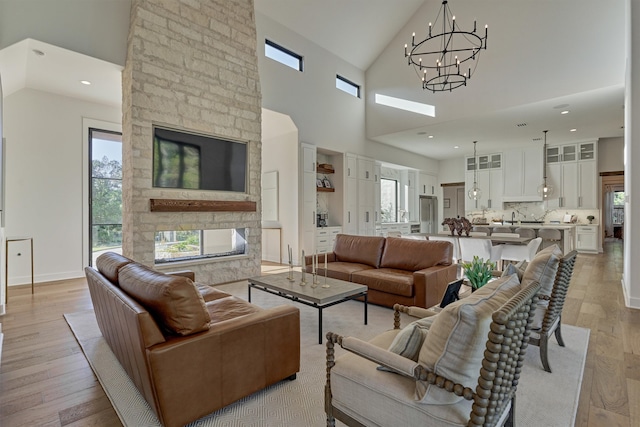 living room with light hardwood / wood-style flooring, high vaulted ceiling, and a notable chandelier