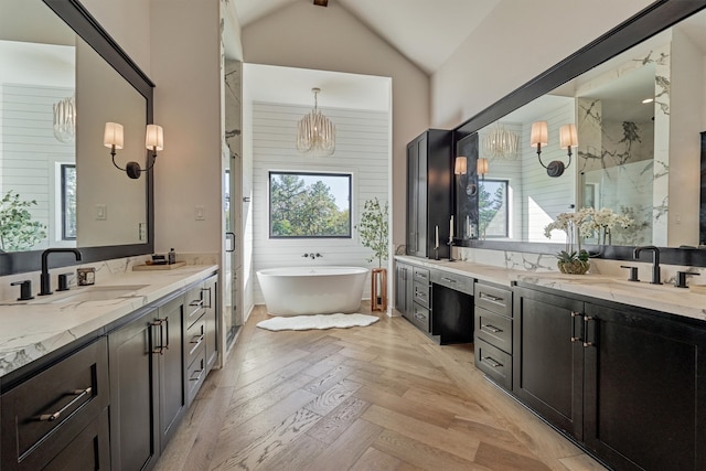 bathroom featuring wood-type flooring, vanity, a wealth of natural light, and lofted ceiling