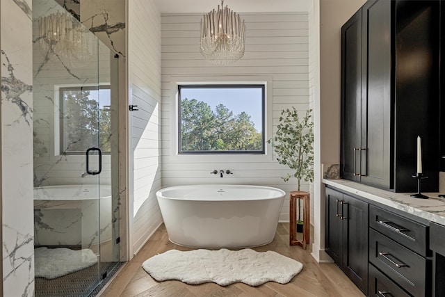 bathroom featuring wood-type flooring, independent shower and bath, and wooden walls