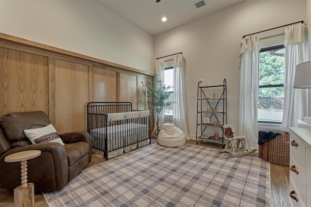 bedroom with a crib and light hardwood / wood-style floors