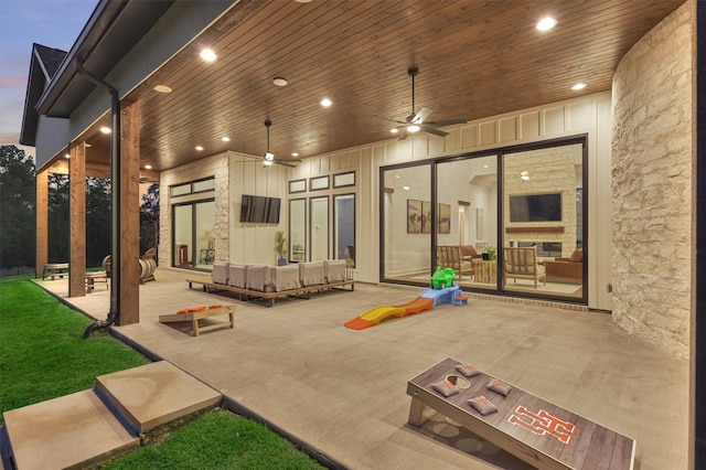 patio terrace at dusk with ceiling fan and an outdoor living space