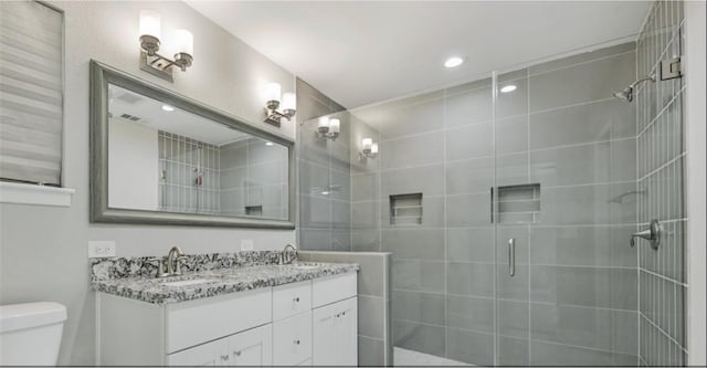 bathroom with vanity, toilet, and walk in shower