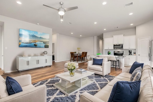 living room featuring hardwood / wood-style floors and ceiling fan