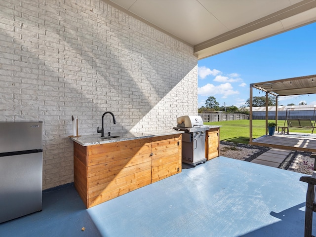 view of patio with area for grilling and sink