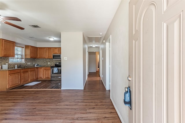 kitchen featuring decorative backsplash, ceiling fan, dark wood-type flooring, and appliances with stainless steel finishes