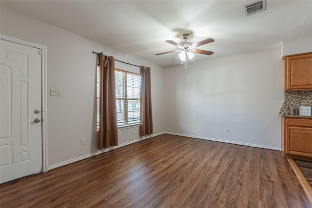 unfurnished living room featuring ceiling fan and dark wood-type flooring