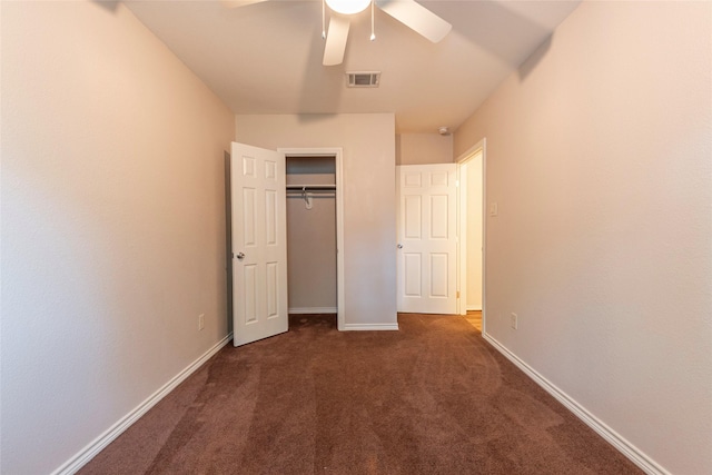 unfurnished bedroom featuring ceiling fan, dark carpet, and a closet