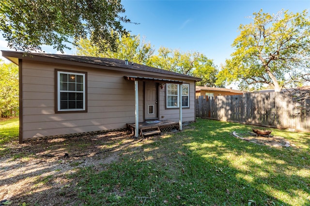 view of front of property with a front lawn and an outdoor fire pit