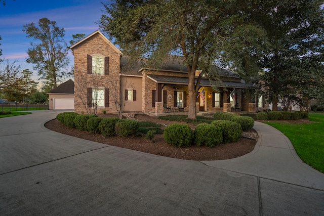 view of front of house with covered porch, metal roof, and concrete driveway