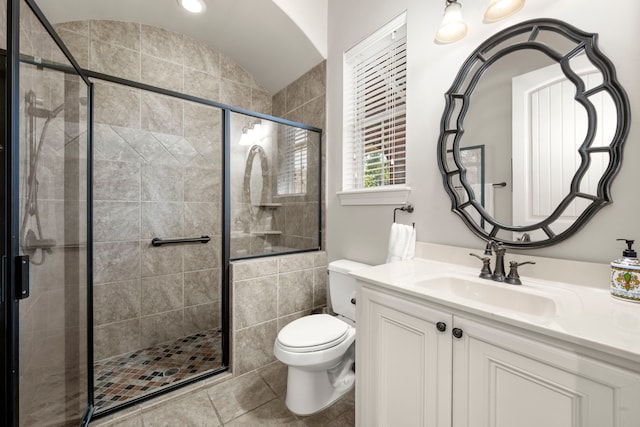 full bath with a stall shower, vanity, toilet, and tile patterned floors