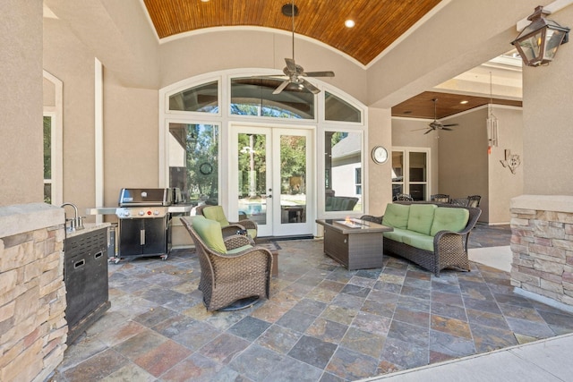 view of patio with french doors, a ceiling fan, a grill, exterior kitchen, and an outdoor living space