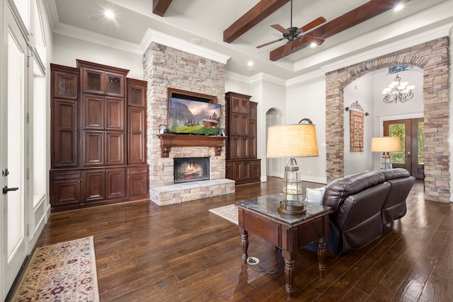 living area featuring arched walkways, a fireplace, french doors, beamed ceiling, and dark wood finished floors