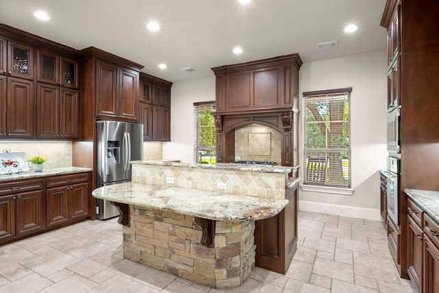 kitchen with stainless steel appliances, recessed lighting, stone tile flooring, visible vents, and tasteful backsplash