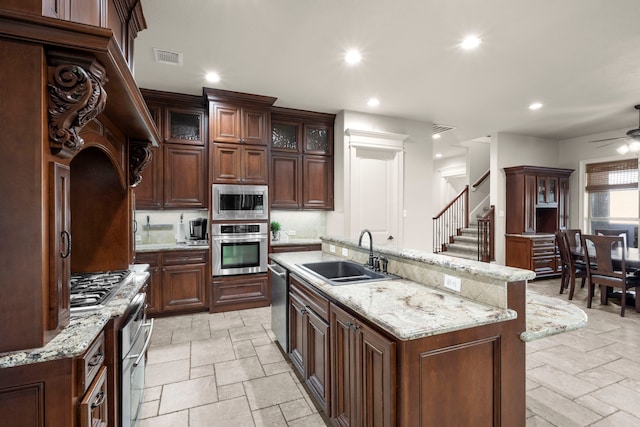 kitchen with stone tile flooring, stainless steel appliances, a sink, and recessed lighting