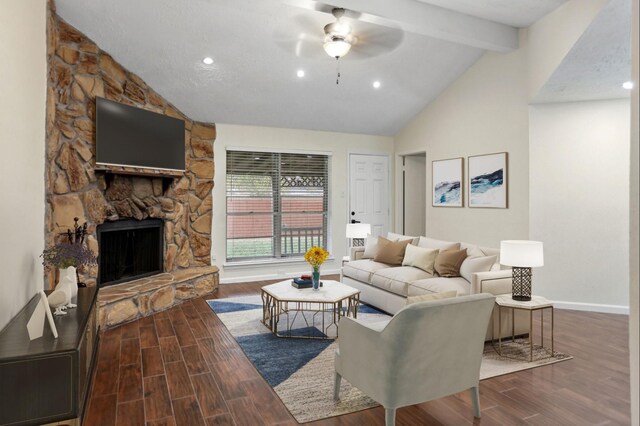 living room with vaulted ceiling with beams, a stone fireplace, and ceiling fan