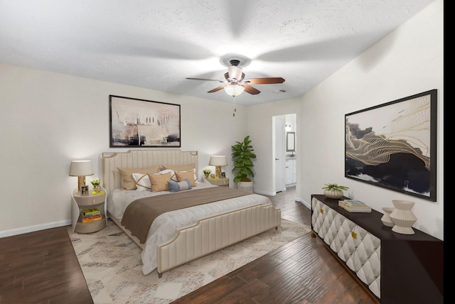 bedroom featuring ceiling fan, wood-type flooring, a textured ceiling, and ensuite bath