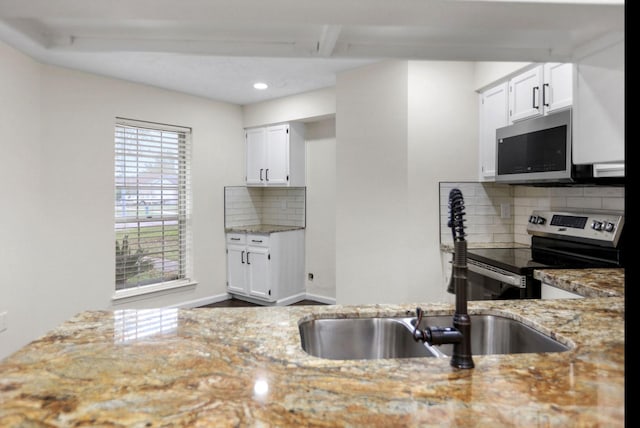 kitchen featuring light stone counters, appliances with stainless steel finishes, sink, and white cabinets