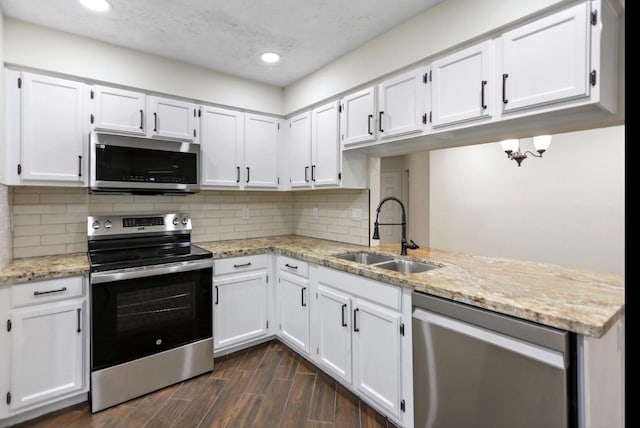 kitchen featuring sink, white cabinetry, light stone counters, dark hardwood / wood-style flooring, and stainless steel appliances