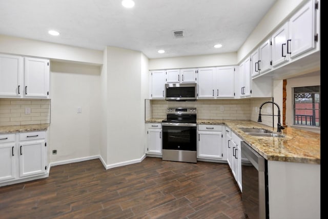 kitchen featuring light stone counters, sink, white cabinets, and appliances with stainless steel finishes