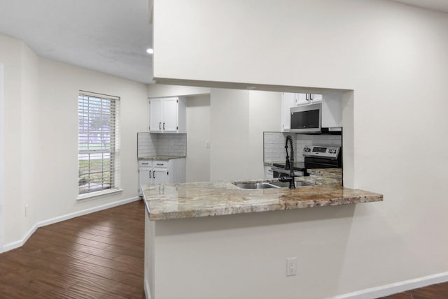 kitchen with white cabinetry, appliances with stainless steel finishes, sink, and kitchen peninsula