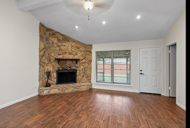 unfurnished living room with vaulted ceiling with beams, a fireplace, dark hardwood / wood-style floors, and ceiling fan