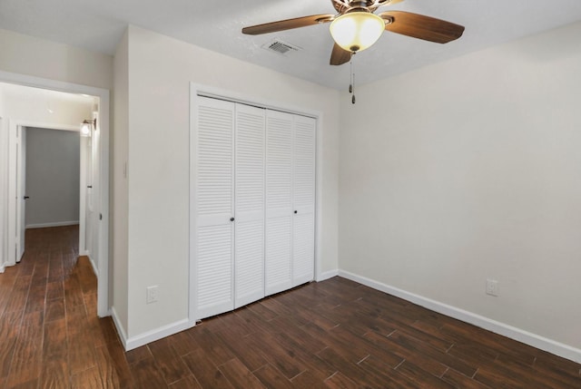 unfurnished bedroom featuring dark wood-type flooring, ceiling fan, and a closet