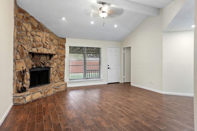 unfurnished living room with lofted ceiling with beams, ceiling fan, a stone fireplace, and dark hardwood / wood-style flooring