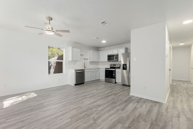 kitchen with white cabinets, sink, light hardwood / wood-style flooring, ceiling fan, and appliances with stainless steel finishes