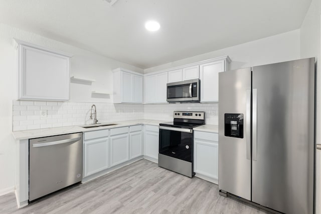 kitchen featuring white cabinets, light hardwood / wood-style floors, sink, and appliances with stainless steel finishes