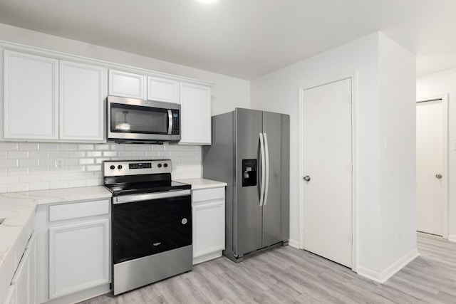 kitchen featuring decorative backsplash, light stone countertops, stainless steel appliances, light hardwood / wood-style flooring, and white cabinets