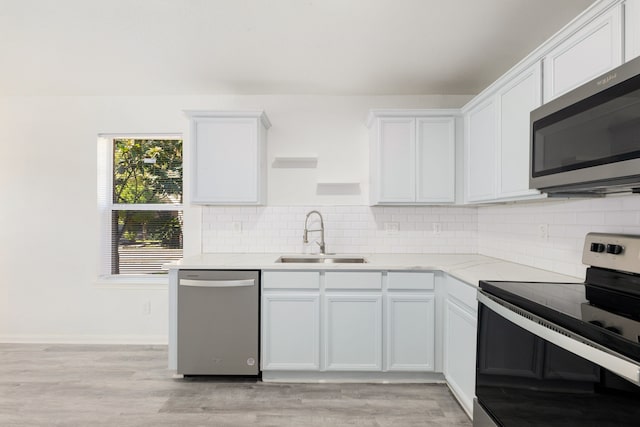 kitchen with sink, white cabinets, stainless steel appliances, and light wood-type flooring