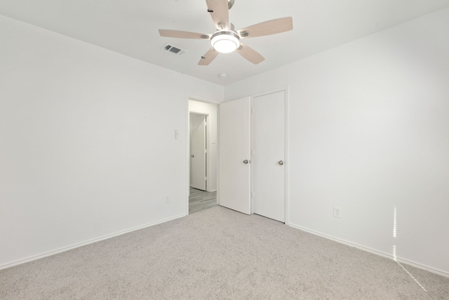 carpeted spare room featuring ceiling fan