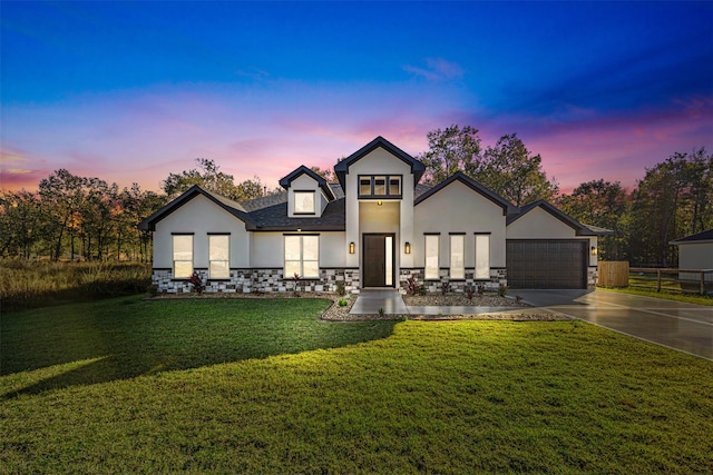 view of front of property with a garage and a yard