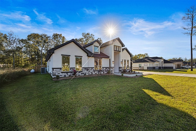 view of front of home with a front yard and central air condition unit