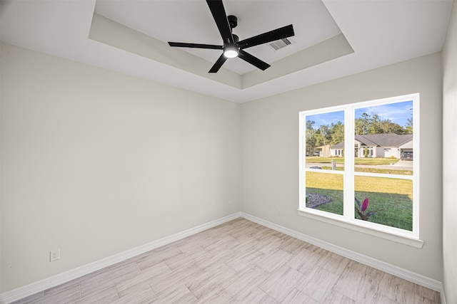 spare room with a raised ceiling and ceiling fan